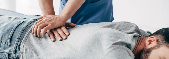 Chiropractic Torrance CA Chiropractic Adjustment A patient in a grey shirt receiving a back adjustment.
