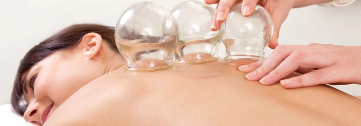 A person with glass cupping cups on their back.