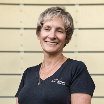 Chiropractic Torrance CA Gayle Ferruccio 1 Gayle Ferruccio smiling in a grey shirt.