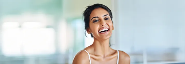 A dark haired woman smiling.