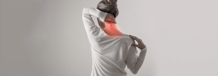A woman holding her neck in pain.