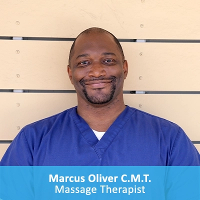 Maasge Therapist Marcus Oliver In Front Of Wooden Wall With Caption